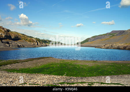 Llyn Peris in Snowdonia liegt in der Nähe von Llanberis. Dieser gletschersee wird von der ehemaligen Schiefergrube der Dinorwig flankiert und ist jetzt ein Reservoir. Stockfoto