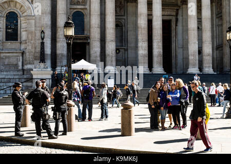 Bewaffnete Polizei sprechen und die Touristen, die eine Gruppe Selfie Seite an Seite außerhalb von St. Pauls Kathedrale in London Vereinigtes Königreich Stockfoto