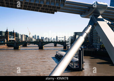 Blick auf die Tower Bridge über die Themse vom Millennium Foot Bridge in Bankside mit Canary Wharf in tyhe Hintergrund Stockfoto