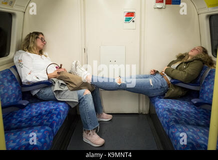 Nacht Tube. Zwei Passagiere schlafen in den frühen Stunden während einer Nacht Fahrt mit der U-Bahn auf der Northern Line in Central London, UK. Stockfoto