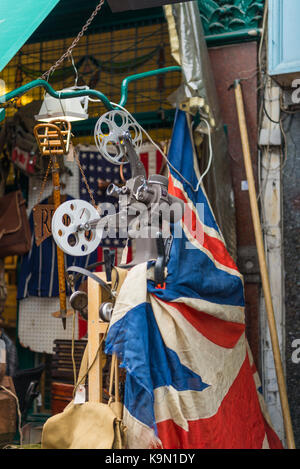 Alte cine Projektor auf Display mit alten, verblasst, Union Jack Flagge und anderen Bric-a-brac außerhalb einer shopfront in der Portobello Road, London, UK. Stockfoto