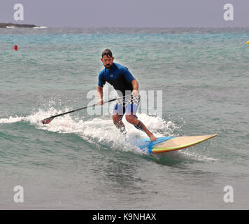 Die Menorquinische Ferienort Punta Prima im Mittelmeer mit männlichen Paddle Board surfen Stockfoto