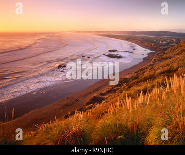 Neuseeland. North Island, Port Waikato Küste bei Sonnenuntergang. Stockfoto