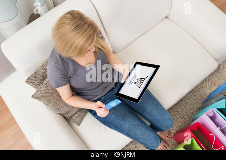Hohe Betrachtungswinkel und der jungen Frau Shopping Online auf Tablet zu Hause Stockfoto