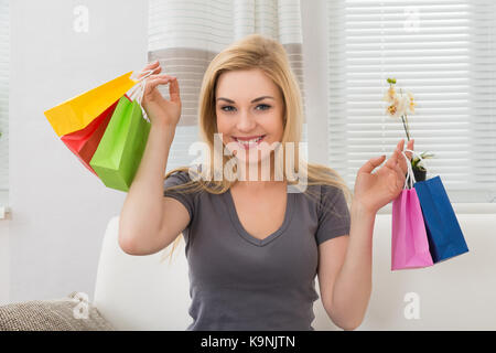 Junge schöne Frau mit bunten Tüten Stockfoto