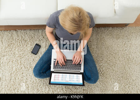 Hohe Betrachtungswinkel und der jungen Frau mit der Eingabe auf Laptop Übersicht Kalender auf Display Stockfoto