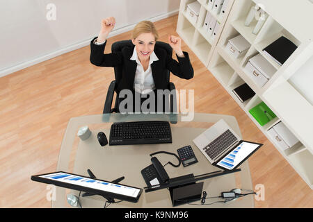 Junge glücklich Geschäftsfrau Anheben der Arme im Büro Stockfoto