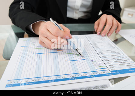 Nahaufnahme der Geschäftsfrau mit Stift Arbeiten auf Gantt-diagramm am Schreibtisch Stockfoto