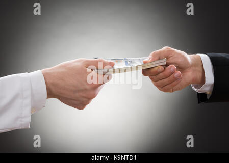 Nahaufnahme der Geschäftsmann Hand Geld zu geben Arzt Stockfoto