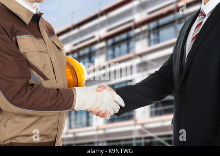 Nahaufnahme eines Architekten tragen Handschuh zitternden Hand mit Geschäftsmann Stockfoto