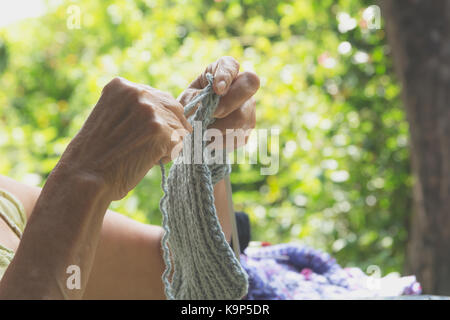 Die alte Frau strickt Wollsachen. close-up von Hand stricken. Stricknadeln. Stockfoto