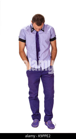 Verärgert jungen Mann stehen, die Hände in den Taschen, vor einem weißen Hintergrund isoliert. Stockfoto