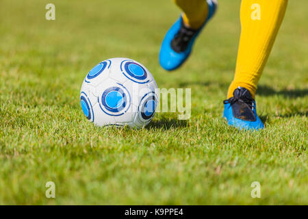 Nahaufnahme der Füße eines footbal Spieler kicken den Ball. Konzentrieren Sie sich auf den Ball. Stockfoto