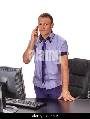 Junge Unternehmer die stehen in der Nähe von seinem Schreibtisch und über ein Mobiltelefon, vor einem weißen Hintergrund isoliert. Stockfoto