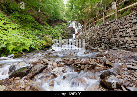 Stein Weg entlang dem Wasserfall Shipit zwischen den grün bewachsenen Hügeln in den ukrainischen Karpaten Stockfoto