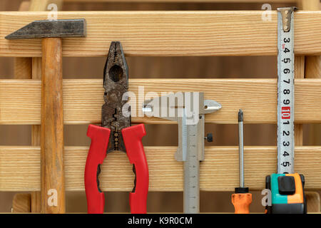 Alte Construction Tools sind vertikal auf Pine horizontalen Holzlatten close-up entfernt Stockfoto