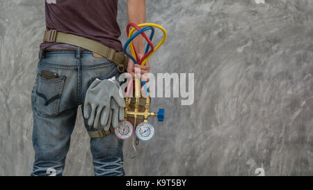 Des Menschen Hand mit einem Manometer auf Anlagen zum Befüllen von Klimaanlagen mit Kopie Raum Hintergrund Stockfoto