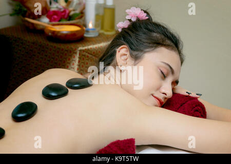 Frau, die entspannende Hot Stone Massage im Spa Salon Stockfoto