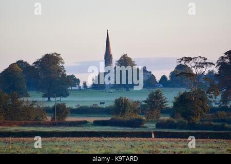 Sonnenaufgang über die Felder und den Golfplatz in dem kleinen Dorf Kingweston Somerset UK mit der Kirche im Hintergrund Stockfoto