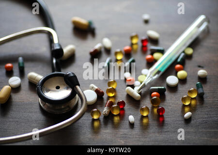 Medikamente und Tabletten auf einer hölzernen Textur Tabelle Stockfoto