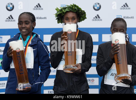 Berlin, Deutschland. 24 Sep, 2017. Gladys (M) Cherono aus Kenia, Sieger des Marathons, Alemitu Bekele Aga (L) von Äthiopien auf den zweiten Platz und Valary Jemeli Aiyabei aus Kenia, die Dritten stellen mit großen Bierkrüge während der Preisverleihung des Berlin-Marathon in Berlin, Deutschland, 24. September 2017 gestellt. Credit: Soeren Stache/dpa/Alamy leben Nachrichten Stockfoto