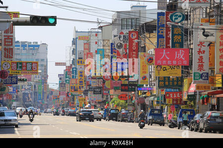 Unbekannter Fahrer sind auf der Straße, die voll von Werbung in Taichung Stockfoto