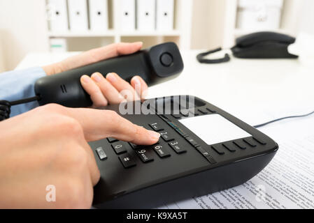 Nahaufnahme der Unternehmer Wählen der Nummer über das Tastenfeld des Telefons Stockfoto