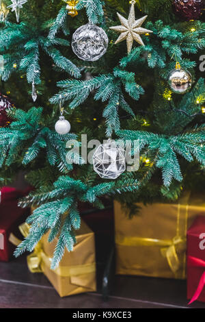 Schöne Boxen mit Geschenken unter dem geschmückten Weihnachtsbaum Stockfoto