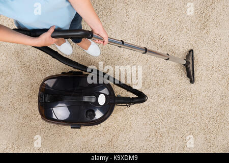 In der Nähe von Frau saugen Teppich zu Hause Stockfoto