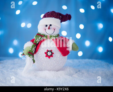 Süße snowman Spielzeug auf blauem Hintergrund mit einem schönen Bokeh Stockfoto