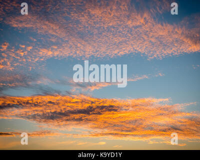 Blauer Himmel mit Licht, orange farbige Wolken bei Sonnenuntergang Stockfoto