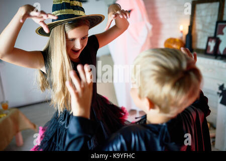 Lustige emotionale Kinder in Halloween Kostüme, Rollenspiel und Erschrecken einander Imaging, dass sie Monster auf Halloween Party sind Stockfoto