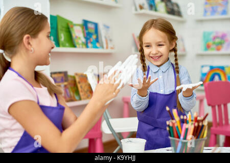 Porträt von zwei kleinen Mädchen genießen Kunst und Handwerk Lektion in der Entwicklung der Schule und glücklich lächelnd während der Arbeit mit Ton und Gips Stockfoto