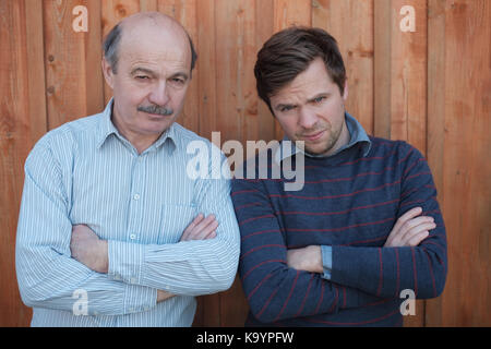 Vater und Sohn stritten. Sie schauen mit verärgerten Emotion an Kamera, Arme gekreuzt Stockfoto