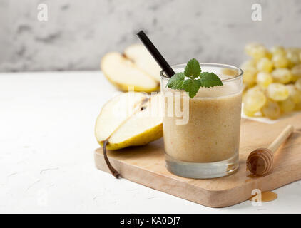 Smoothies von Birnen und Trauben in einem Glas auf einem weißen Hintergrund konkrete Stockfoto