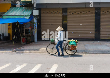 SAIGON, VIETNAM - Oktober 16, 2014: Straße Anbieter auf einer kleinen Straße, Saigon, Vietnam. Es gibt viele Straßenhändler in Saigon. Stockfoto