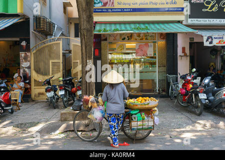 SAIGON, VIETNAM - Oktober 16, 2014: Straße Anbieter auf einer kleinen Straße, Saigon, Vietnam. Es gibt viele Straßenhändler in Saigon. Stockfoto