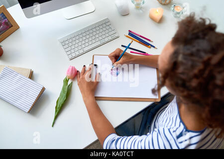 Hohen winkel Porträt der jungen Frau Zeichnung Skizze der Schöne Tulpe Blume am Schreibtisch in der modernen Apartment Stockfoto