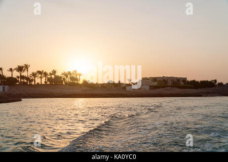 Sonnenuntergang in der Stadt von El Gouna. Wellen auf dem Wasser. Stockfoto