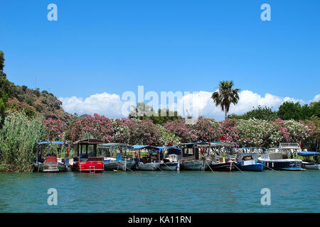 Mit Oleander-Blumen bedeckte Boote entlang der hübschen Uferstadt Dalyan, Türkei Stockfoto