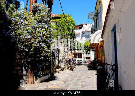 Skiathos, Griechenland. September 13, 2017. Eine bunte Straße in der Stadt Skiathos, wo die Natur übernimmt mit Blumen und Kletterpflanzen in die Seitenstraßen Stockfoto
