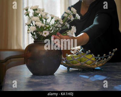 Frau arrangieren Blumenstrauß in der Vase, Innen zugeschnittene Bild Stockfoto