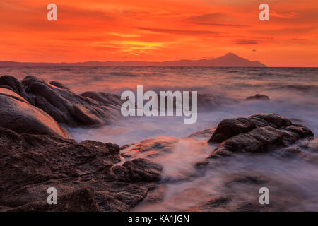 Vourvourou - Karidi Strand mit dem Berg Athos im Hintergrund überrascht bei Sonnenaufgang. Stockfoto