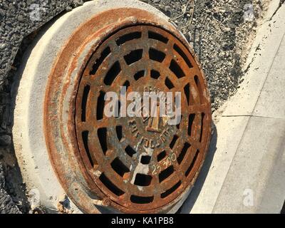 Rostigem Eisen Mannloch in Asphalt Oberflächen Stockfoto