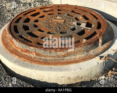 Rostigem Eisen Mannloch in Asphalt Oberflächen Stockfoto