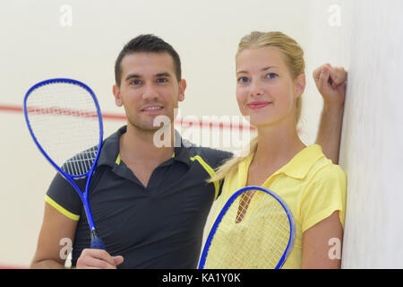 Junge fröhliche Paare nach dem spielen Badminton Stockfoto