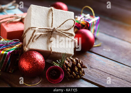 Geschenkboxen und Kugeln auf einem Holztisch. Stockfoto