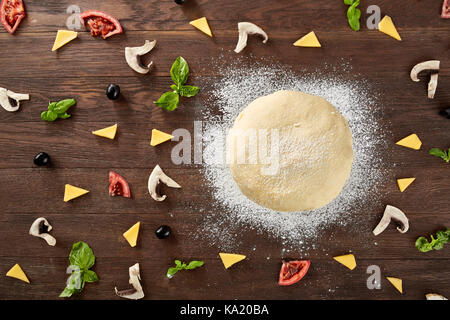 Teig Grundlage und Zutaten für Pizza, auf dem Tisch Stockfoto