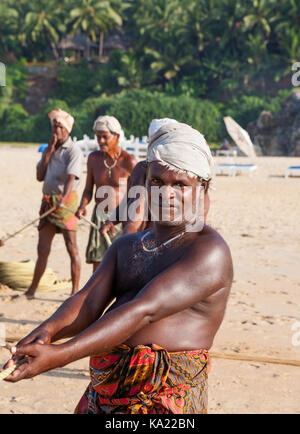 Ländliche Bewohner im täglichen Leben. Den Fischern am Ufer des Ozeans ziehen. Chowara, Kerala, im Südwesten Indiens. Stockfoto
