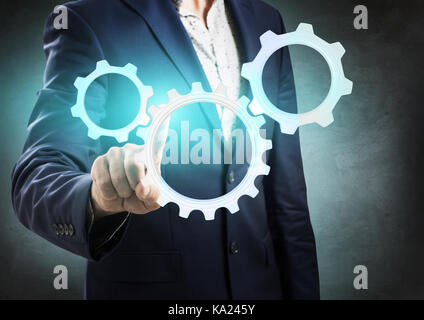 Geschäftsmann Druck auf die Gruppe der Zahnräder. Stockfoto